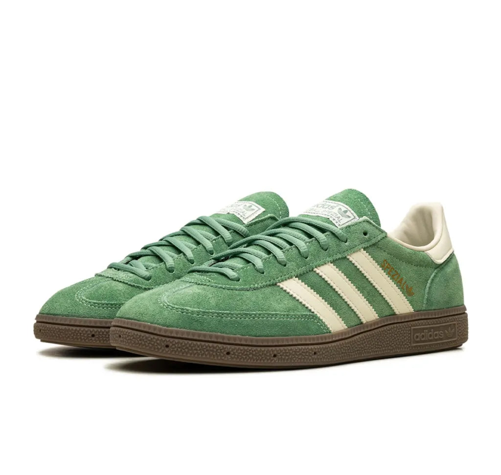 Green Adidas sneakers with white stripes on a white background