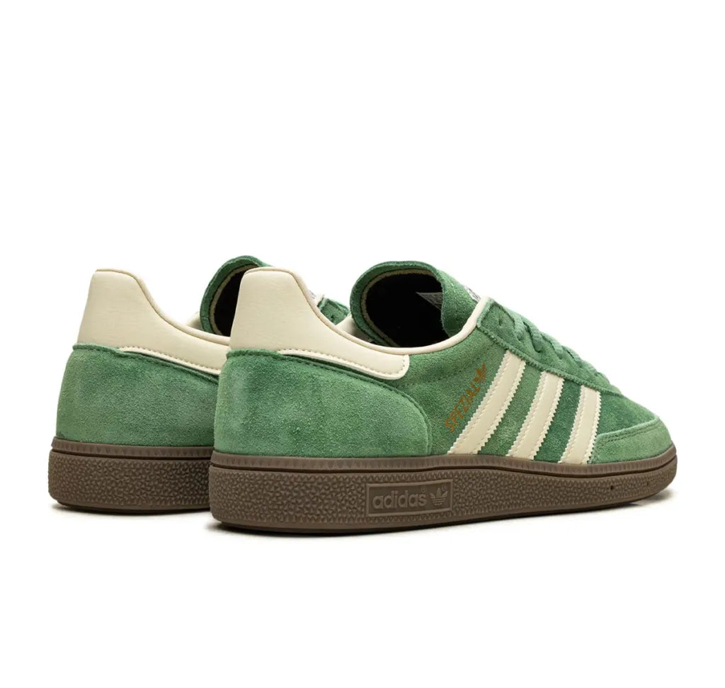 Green Adidas sneakers with white stripes on a white background